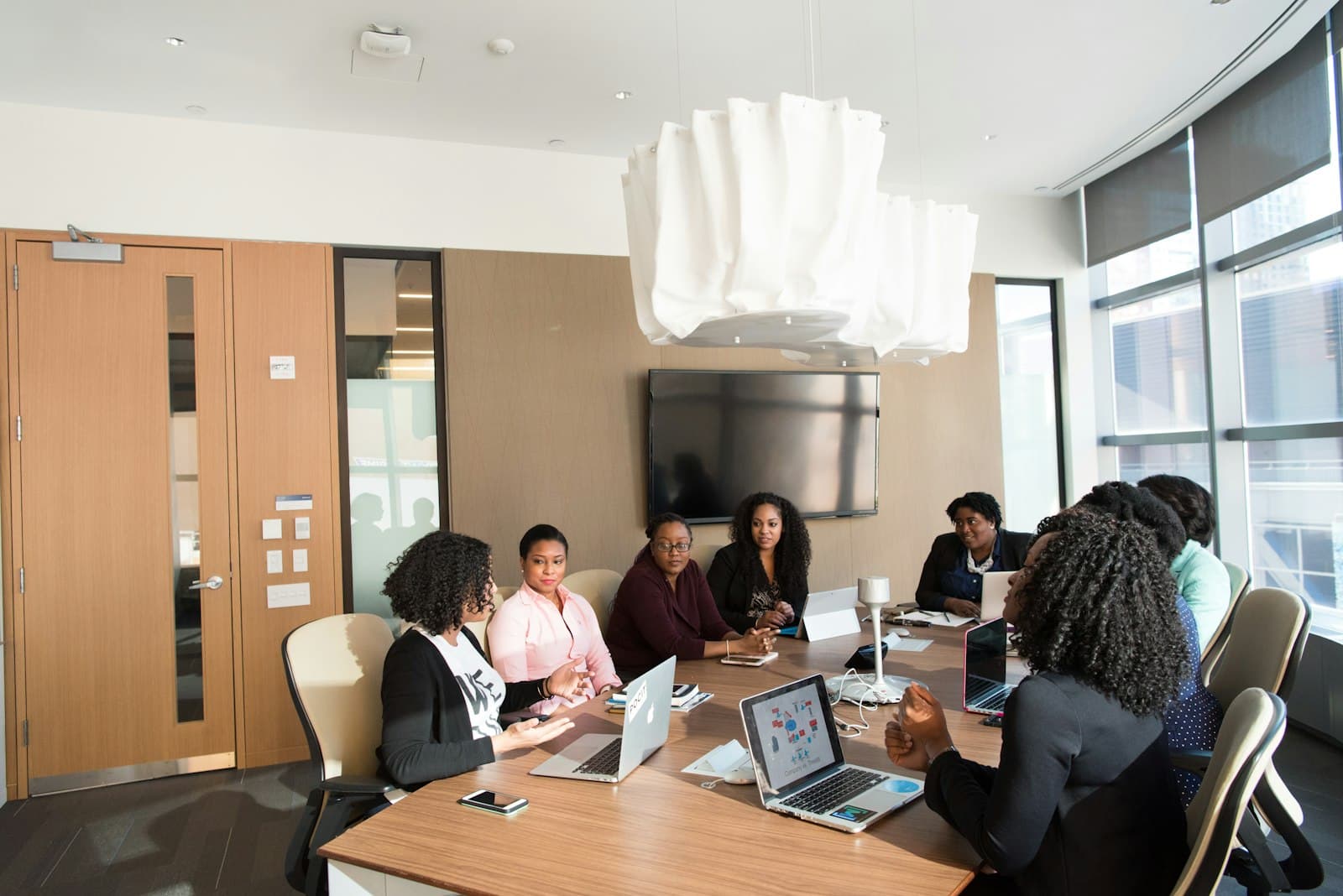 Consultants and organisation stakeholders discussing an engagement around a boardroom table